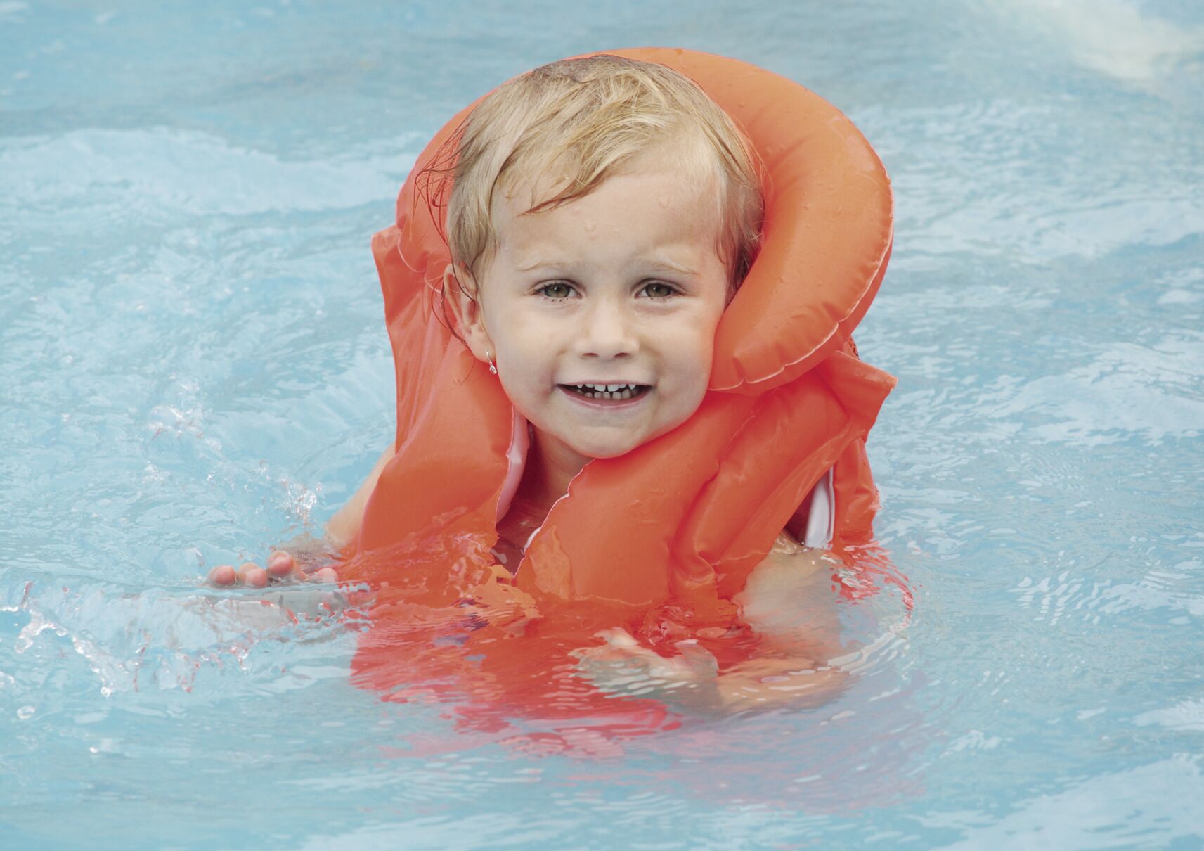 Little child in the life jacket floating.